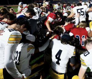 Christian and Bishop O'Down players share a prayer following Friday's game. / CHS